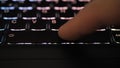 Finger pressing an enter key. Computer user hitting the enter key, up close. Confirmation, sending a message
