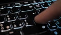 Finger pressing an enter key. Computer user hitting the enter key, up close. Confirmation, sending a message