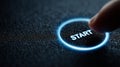 Finger pressing glowing start button in dark futuristic interface Royalty Free Stock Photo