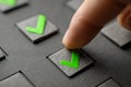 Finger pressing a green check mark button on a textured control panel symbolizing approval, confirmation, and successful Royalty Free Stock Photo