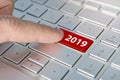 Finger pressing keyboard key written 2019 newyear. finger presses a button on the gray keyboard. Beginning of new year. Royalty Free Stock Photo