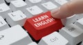 Finger pressing learn english key on a computer keyboard. Online english language learning concept, modern education, or studying Royalty Free Stock Photo