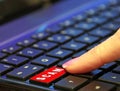 Finger pressing pushing down red hoax scam computer keyboard button word Royalty Free Stock Photo