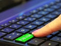 Finger pressing pushing green publish button computer keyboard