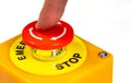 Finger pressing pushing a simple red emergency stop push button, machine rotation release safety switch. Workplace safety, health