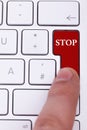 Finger pressing a red stop button on keyboard Royalty Free Stock Photo