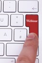 Finger pressing on red webinar button on metallic keyboard Royalty Free Stock Photo