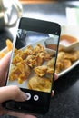 Finger pressing on smartphone for photograph chinese food in res Royalty Free Stock Photo