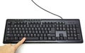 Finger pressing Spacebar button on the black keyboard