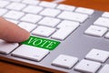 Finger pressing on vote green button on keyboard Royalty Free Stock Photo