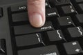 Finger pushing Enter key on black keyboard Royalty Free Stock Photo