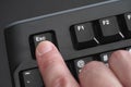 Finger pushing Esc key on black keyboard Royalty Free Stock Photo