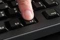 A finger pushing the F1 key on a black computer keyboard Royalty Free Stock Photo