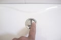 Finger pushing a flush toilet button for cleaning Royalty Free Stock Photo