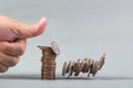 Finger pushing a pile of coins, column of coins falls , business Royalty Free Stock Photo