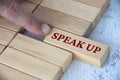 Finger pushing wooden block with written text speak up. Courage and speak up concept