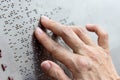 Finger reading braille tactile on public park message board