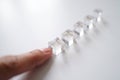 Finger Selecting Clear Acrylic Cube Lined Up Next To Other Cubes For Individualistic Focus And Choice On White Background In Soft Royalty Free Stock Photo