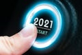 Finger to press a car ignition button with the text 2021 start. new year concept