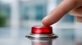 Finger about to press a glossy red emergency button on a metallic surface with a blurred background representing urgency and Royalty Free Stock Photo