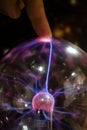 Finger touching an energy ball with a lightning light ray crossing a sphere Royalty Free Stock Photo