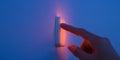 Finger touching glowing light switch with soft blue Royalty Free Stock Photo