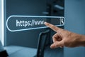 Finger touching a glowing search bar with https www on a blue screen for website or internet concept Royalty Free Stock Photo