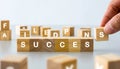 finger touching a wooden cube english alphabet Sort into words that mean success. Royalty Free Stock Photo