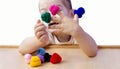 Finger toys in the hands of a little girl. A happy, cheerful girl is playing with doll knitted hats on her hands.  The baby is sit Royalty Free Stock Photo