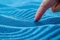 finger tracing wave patterns in blue sand Royalty Free Stock Photo