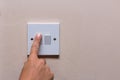 Finger turning off the light to save on consumption