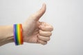 A finger up hand wearing lgbt rainbow gay pride bracelet