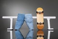 Fingerboard and jeans near a white metal railing