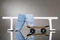 Fingerboard, jeans and white metal railing for riding small skateboards