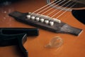 Fingerpick guitar concept: a thumb pick and a guitar capo laying on acoustic guitar