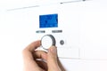 Fingers adjust Gas boiler control panel for hot water and heating. Buttons and a digital display. ÃÂ¡oncept of home heating and Royalty Free Stock Photo