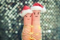 Fingers art of couple celebrates Christmas. Concept of man and woman laughing in New Year hats