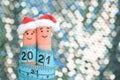 Fingers art of couple celebrates Christmas. Concept of man and woman laughing in New Year hats. Measuring tape is written 2021
