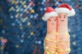 Fingers art of couple celebrates Christmas. Concept of man and woman laughing in New Year hats.