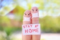 Fingers art of couple is sitting in quarantine at home. People hold placard stay at home to protect yourself from Royalty Free Stock Photo