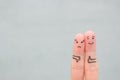 Fingers art of couple. Woman showing thumb down and man showing thumb up. Concept of disagreement in family