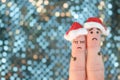 Fingers art of displeased couple celebrates Christmas. Concept of sad man and woman in new year hats