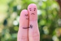 Fingers art of displeased couple. Man is sad, woman reassures her. She kisses and hugs hes