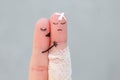 Fingers art of displeased couple. Man is sick, woman feels sorry for him. She kisses his Royalty Free Stock Photo