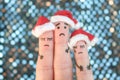 Fingers art of displeased family celebrates Christmas. Concept of group of sad people in new year hats