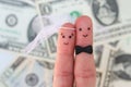 Fingers art of a Happy couple. Bride and groom hug on background of money.