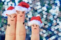 Fingers art of happy couple laughing in New Year hats. Man and woman hugs. Child is angry. Royalty Free Stock Photo