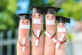 Fingers art of students in medical mask from COVID-2019. Graduates holding their diploma after graduation