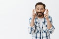 Fingers crossed for good luck. Portrait of nervous charming adult caucasian man in checked shirt, praying or making wish Royalty Free Stock Photo