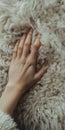 Close-up of a hand touching soft, fluffy wool texture, emphasizing warmth and tactile sensation Royalty Free Stock Photo